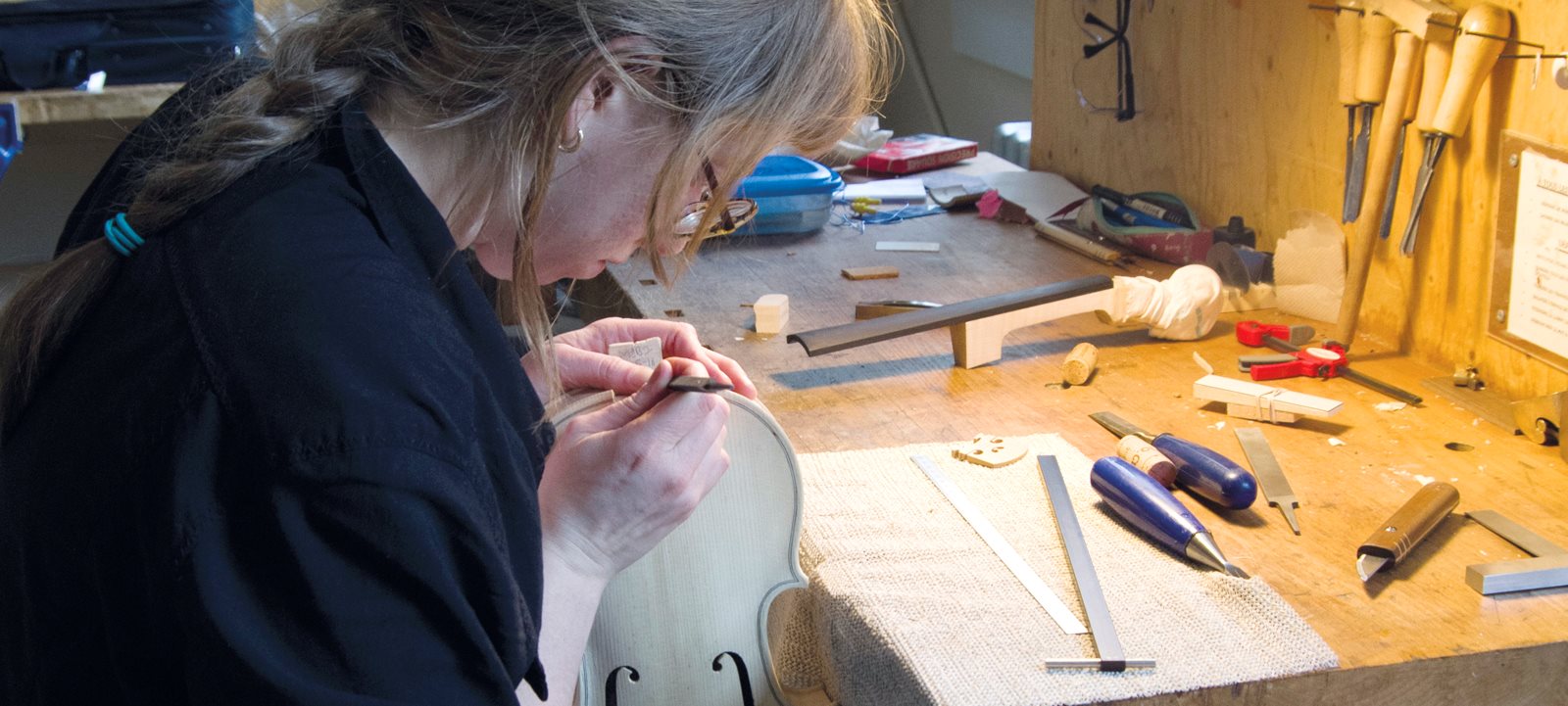 Jeune femme travaillent sur un violon