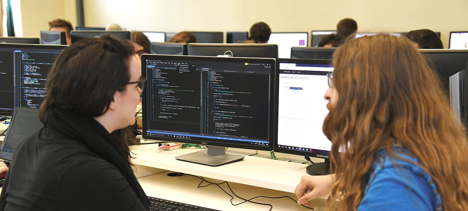 Étudiants devant écran comprenant du code informatique