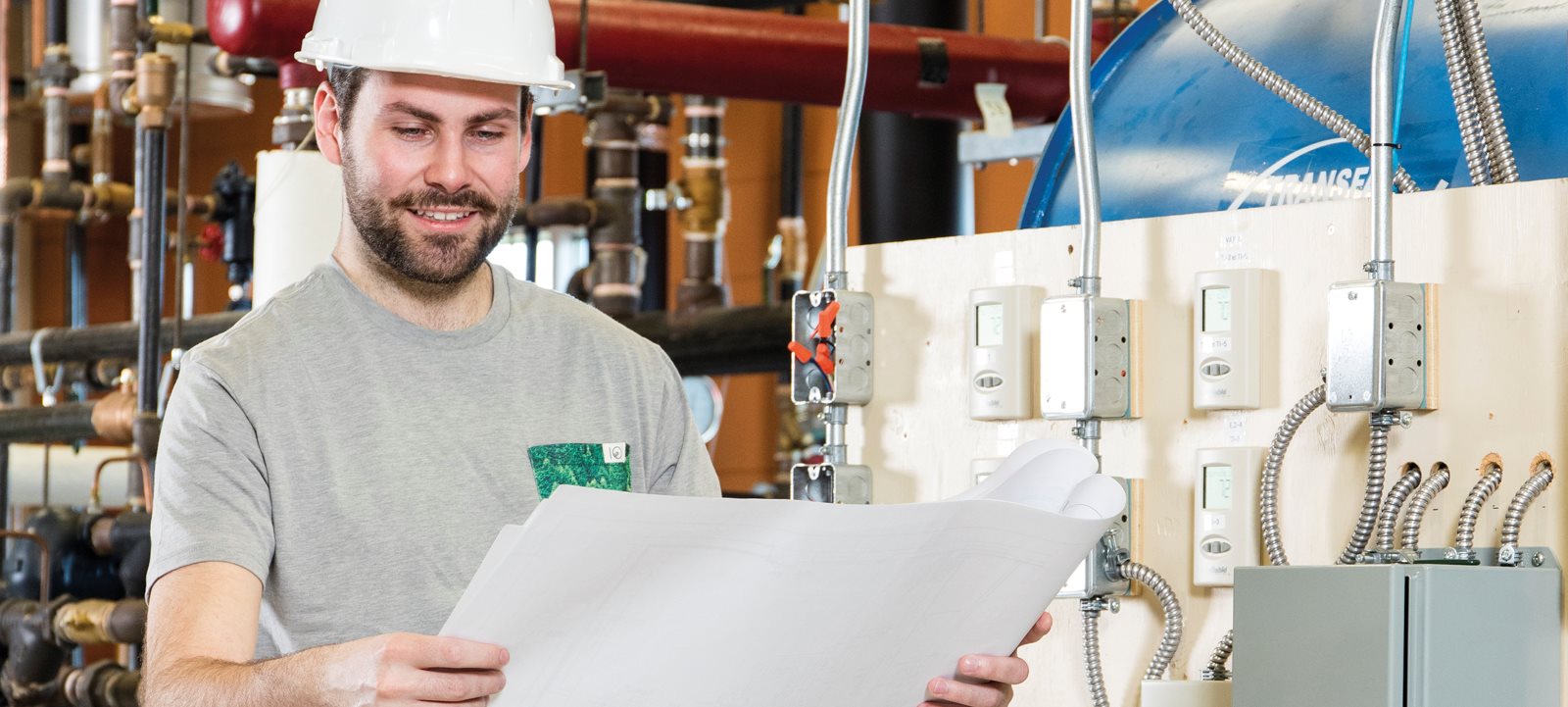 Homme souriant dans une usine regardant un plan