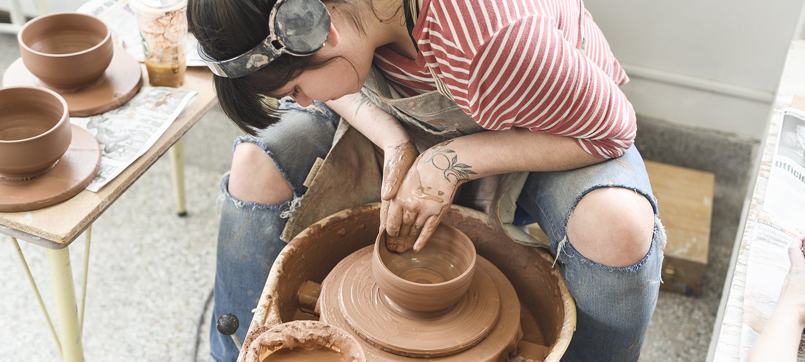 Femme sculptant des bols en argile