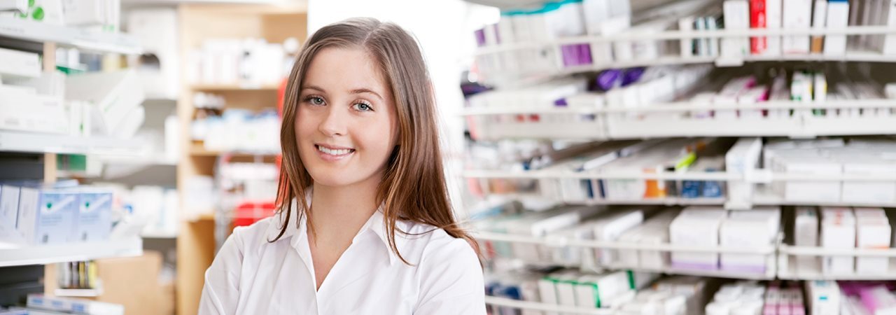 Étudiante qui fait l'inventaire de médicaments sur les tablettes de pharmacie